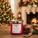 Load image into Gallery viewer, A red hand-poured candle in a clear glass jar with a silver lid sits on a wooden table in a cozy holiday setting. The label reads ''Home 4 the Holidays'. Southern Charm Farmhouse.
