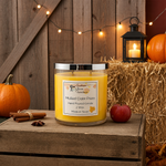 Load image into Gallery viewer, Hand Poured Candle labeled 'Mulled Cider Press' on a wooden surface with pumpkins and hay bale in the background. Southern Charm Farmhouse.

