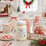 Load image into Gallery viewer, A holiday-themed product display on a kitchen counter featuring a central jar candle labeled 'Marshmallow Wonderland' by 'Southern Charm Farmhouse' surrounded by candy jars, a mug reading 'Merry &amp; Bright,' peppermint candies, and a sign reading 'Candy Canes 25¢.'.
