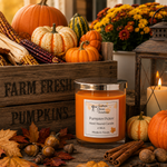 Load image into Gallery viewer, A hand-poured Pumpkin Pickin candle in a clear glass jar with a silver lid sits on a rustic wooden table surrounded by fall decorations, including pumpkins, acorns, cinnamon sticks, and a lantern.  Southern Charm Farmhouse.
