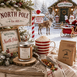 Load image into Gallery viewer, A cozy holiday tabletop scene with multiple Christmas-themed products: a hand poured 2 wick Reindeer Munch candle in a glass jar, a red-and-white striped mug filled with whipped cream, a kraft paper bag labeled 'Reindeer Munch,' and rustic 'North Pole' signs. A real snowy outdoor workshop scene with Santa, reindeer, and sleigh is visible in the background.  Southern Charm Farmhouse
