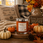 Load image into Gallery viewer, A scented hand poured candle in a clear glass jar with a silver lid sits on a wooden tray in a cozy fall-themed setting with pumpkins, pillows, a plaid throw, and autumn decor.  Southern Charm Farmhouse.

