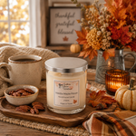 Load image into Gallery viewer, A jar hand poured candle labeled 'Vanilla Maple Pecan' by Southern Charm Farmhouse  is styled on a wooden tray with fall-themed props including pecans, a mug of coffee, a lit amber candle, autumn leaves, pumpkins, and a framed sign in the background.

